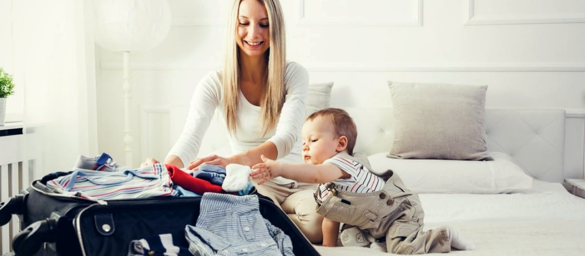 Un enfant et sa mère préparent ensemble les valises de bébé