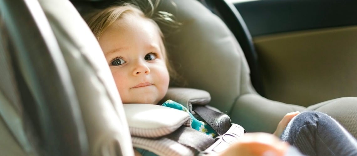 Un bébé habillé confortablement dans le siège auto d'une voiture