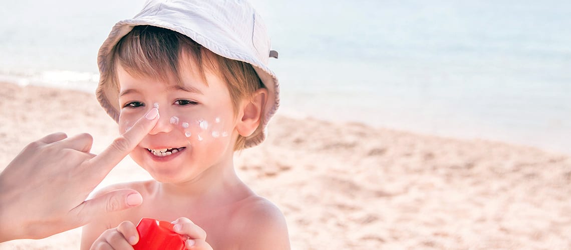 A child with sunscreen on his nose