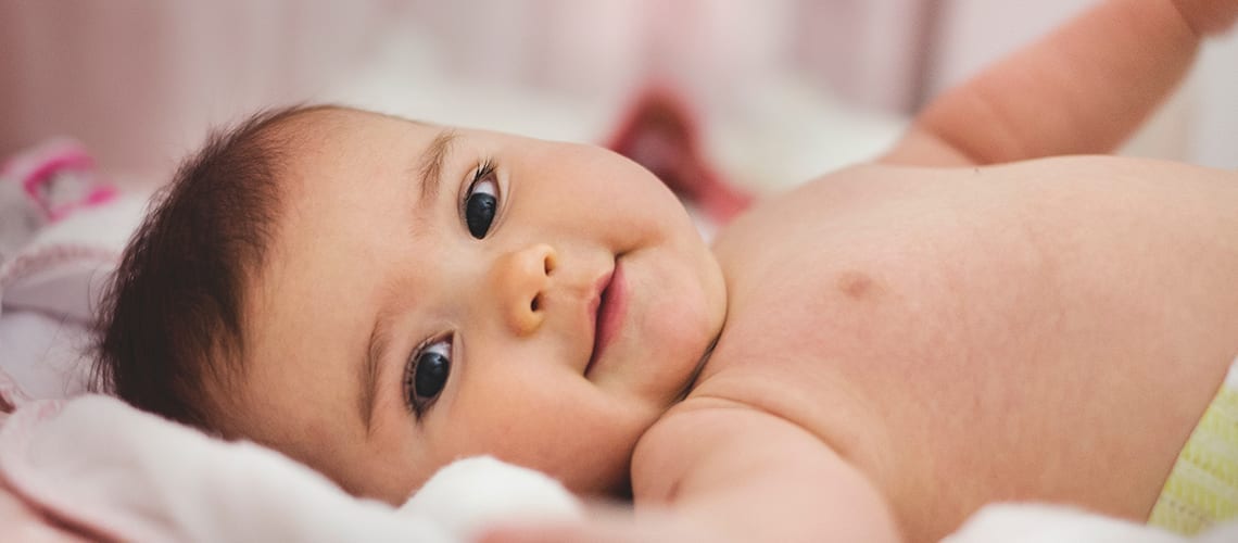 Baby-laying-on-a-pink-blanket