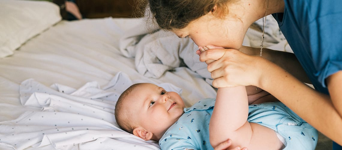 Maman-embrasse-le-pied-de-son-bébé