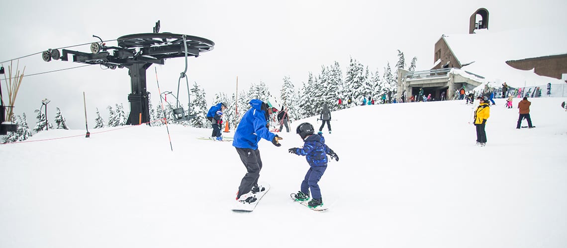 child-snowboard-instructor-mountain