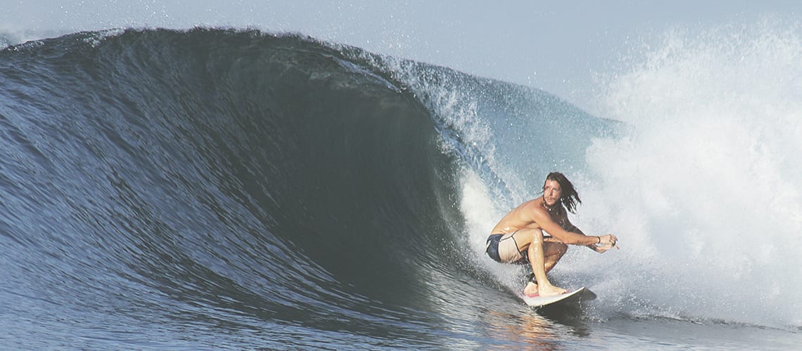 adolescent-faisant-du-surf-dans-la-vague