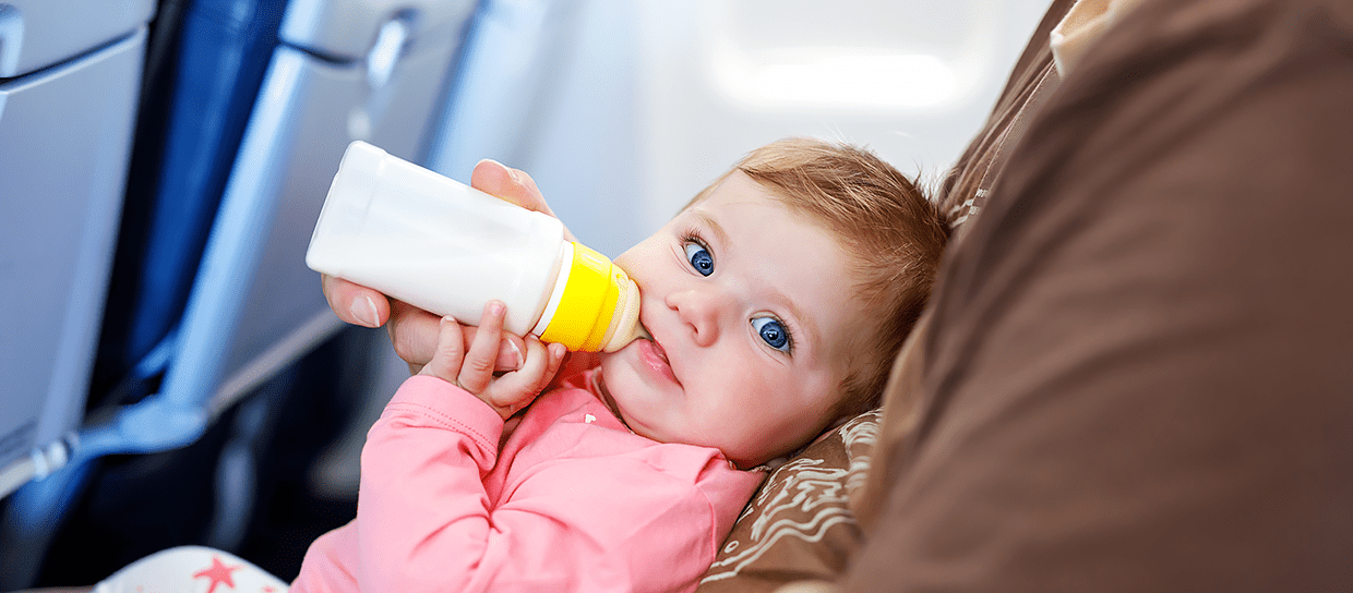 Baby drinks his bottle on the plane