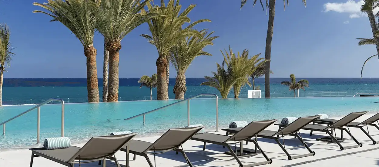 swimming pool-seaside-palm trees-loungers